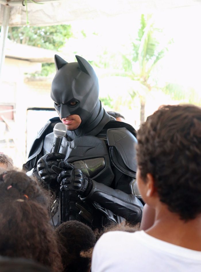 Batman Thyago falando ao microfone para crianças
